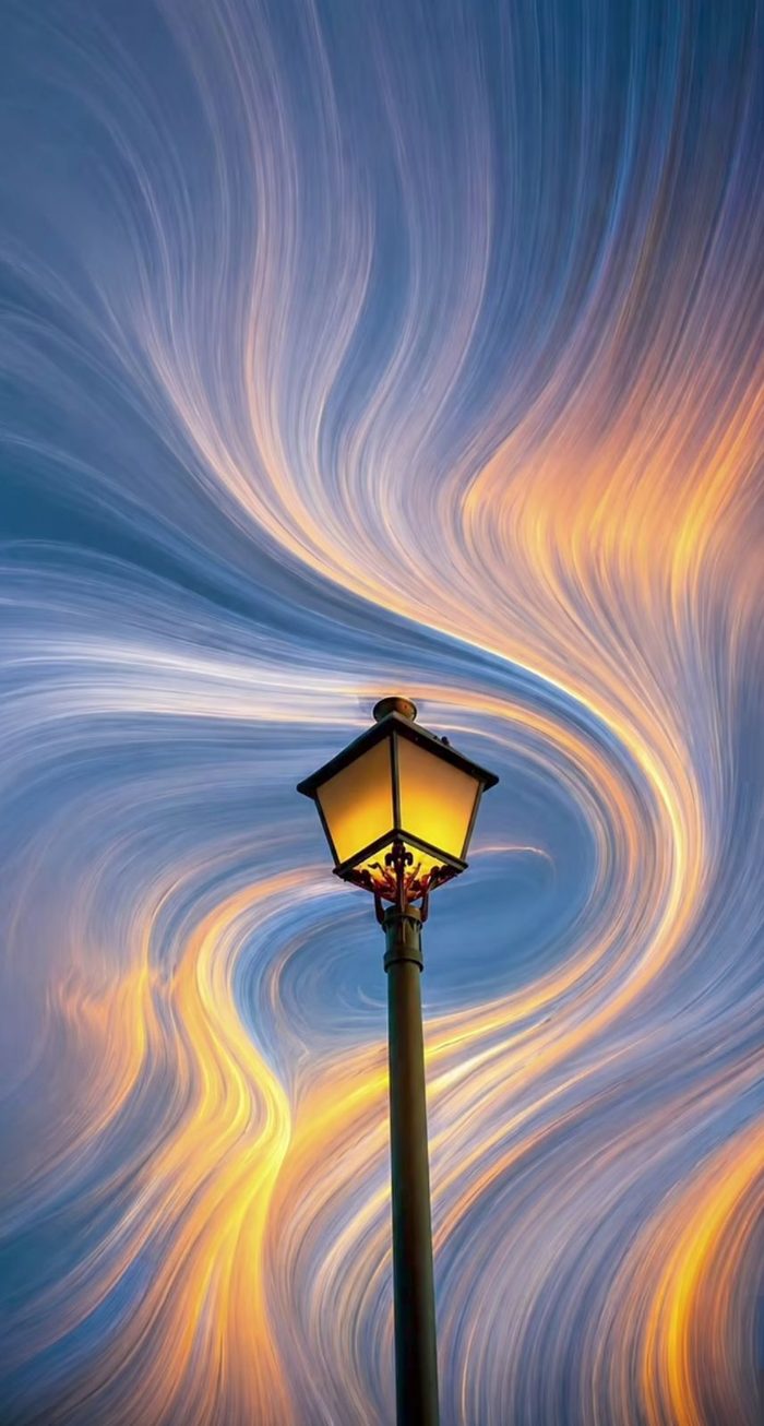 Street lamp against swirling sky